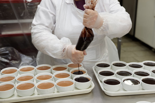 Pastry chaf is adding chocolate to panna cotta