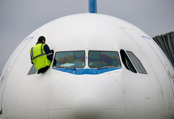 Technicien inspectant les vitres d'un cockpit d'avion