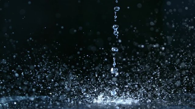 Pouring water on dark background, shooted with high speed cinema camera at 1000 fps. 4K footage.