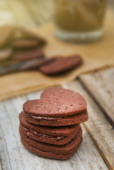 Delicious heart shape homemade chocolate cookies on rustic wooden background. Sweet chocolate dessert or snack.