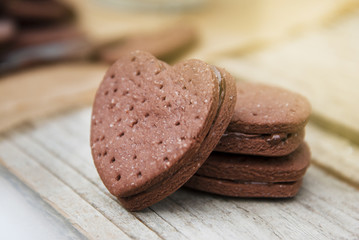 Delicious heart shape homemade chocolate cookies on rustic wooden background. Sweet chocolate dessert or snack.