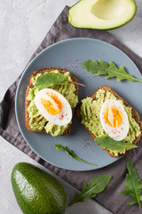 Avocado toasts with eggs and salad on breakfast