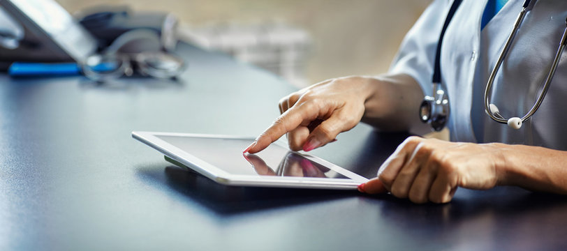 Doctor working on a digital tablet with copy space