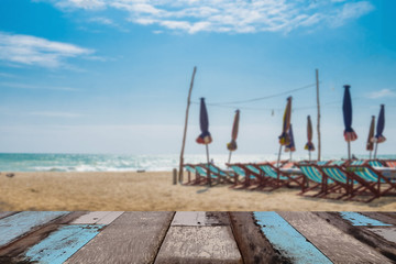 Wood table top with blurred nature scene tropical beach and blue sky, holiday background concept - can be used for display or montage your products.