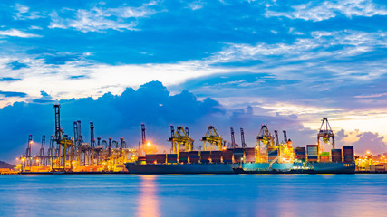 Fototapeta na wymiar Freighter ship loading cargo at loading dock on twilight time. Singapore, south east asia.