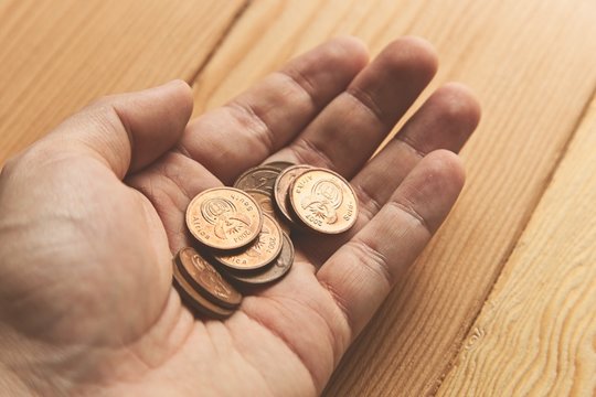 A Hand Holding A Bunch Of South African 5 Cent Coins (money). 