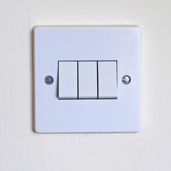 Close up of a triple light switch UK
