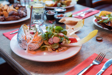Folien Kartoffel mit Sour Cream Joghurt und Salat als Beilage in einem mexikanischen Restaurant serviert