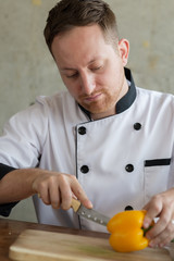 Chef chopping Yellow chili peppers on cutting board, work concept.