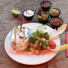 Ofenfolienkartoffel mit Sour Cream Joghurt und Beilagen Salat in einem mexikanischem Restaurant