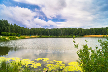 Natural forest lake with artificial sandy beach for free public leisure activities. Moscow residential suburb, Zarya district, Balashikha. Russia.