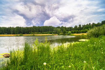 Natural forest lake with artificial sandy beach for free public leisure activities. Moscow residential suburb, Zarya district, Balashikha. Russia.
