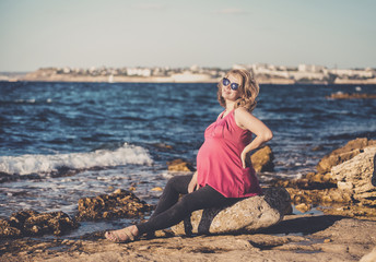 Portrait of beautiful pregnant woman at beach. Toned.