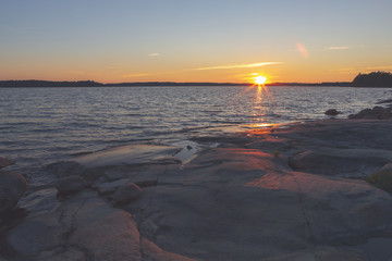 Sunset at the Finnish archipelago. Coastline at the sea. Image has a flare and vintage effect applied.