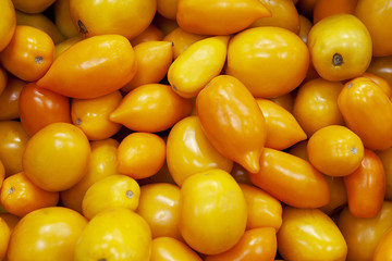 Heap of fresh ripe orange tomatoes without branches.