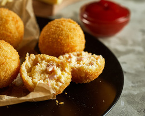 Fresh homemade cheese balls on wooden cutting board