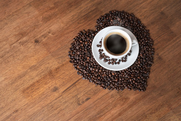 Hot coffee cup with heart pattern of roasted coffee beans