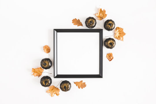 Autumn composition. Photo frame, leaves, pumpkins on white background. Autumn, fall, halloween concept. Flat lay, top view, copy space, square