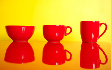 three red cup mug bowl kitchen wear on colorful yellow background