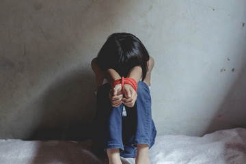Kidnapped little girl tied with rope.Abused and tortured concept. Human trafficking concept. Stop...