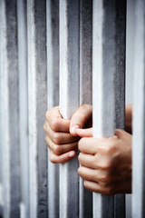hands of prisoner in jail background
