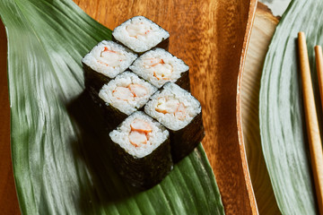Sushi served on wooden plate and green leaf