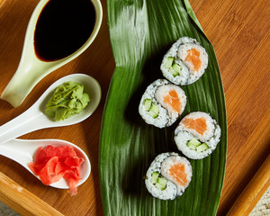 Sushi served on wooden plate and green leaf