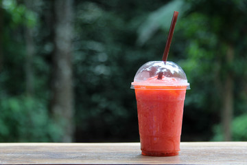 Strawberry juice in plastic transparent glass.