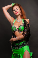 Fototapeta na wymiar Beautiful woman dancing belly dance sexy Arabian Turkish oriental professional dancer in a bright carnival shining suit with long hair. Exotic belly dance star