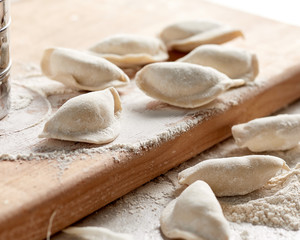 Fototapeta na wymiar Raw russian dumplings with flour on table