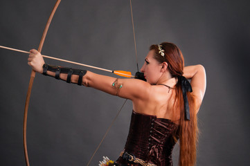 Beautiful slender sporty woman with long hair shoots from an onion