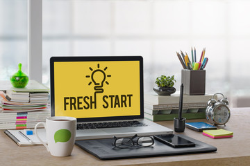 Office workplace with mockup laptop, notebook, coffee, clock and stationery on wooden desk in the morning. Fresh start with idea, Start up or Freelancer concept.