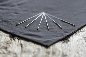 Akupunktur Nadeln auf schwarzem Tuch