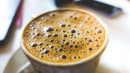 Closeup shot of Cham Coffee with bubbles serve in white cup.