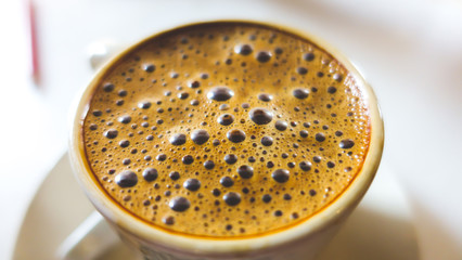 Closeup shot of Cham Coffee with bubbles serve in white cup.