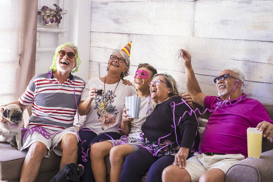 Mixed ages caucasian family at home celebrating an event or party together having a lot of fun. laughs and smiles for happy senior adult and young teenager people in friendship. Happiness and joyful 