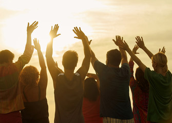 Greeting the sun. People with hands up in the air against sunny sky background.