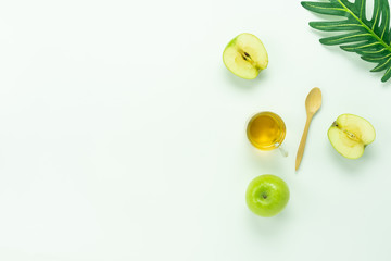 Table top view aerial image of decorations Jewish holiday the Rosh Hashana background concept.Flat lay object sign of variety apple & honey bee cup and wood spoon on modern rustic white wooden wall.