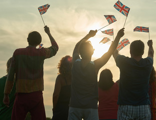 Back view, silhouette of british people with flags. Patriotic british family, rear view.
