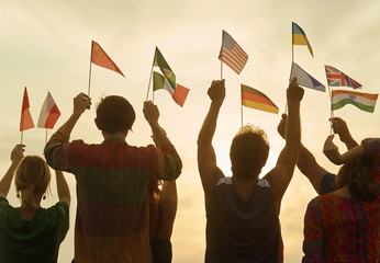 Hands up with flags. Silhouette in evening sky background.