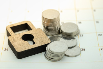 Money security, planning and business concept. Close up of Wooden master key lock icon on calendar...