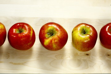 Fresh apples on a wooden table, in one line.
