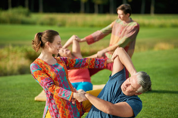 Fototapeta premium Outdoor thai yoga massage portrait. Green summer park background.