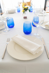 Served table with white plates and blue glasses