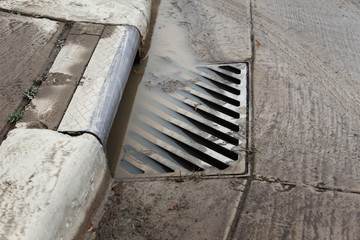 Stormwater filling a flooded sewer drain to the top