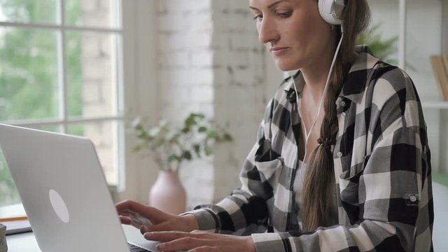 Portrait Of Business Owner Web-design Freelancer, Working Remotely From Home. Smart Attorney Lawyer Woman In Stylish Shit Listening To Music Doing Her Creative Job In Bright Room With Computer Table