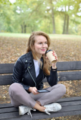 Pretty Young Woman Walking in Autumn Park Relax Leisure Black Leather Jacket Fashion Modern Red Nails Drinking Coffee Take Away Cup
