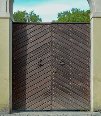 Old wooden gate in a stone fence of yellow color