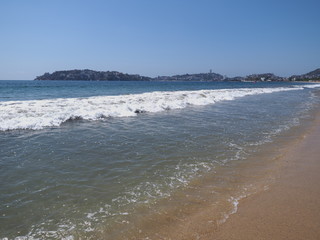 Vacation panorama of sandy beach at bay of ACAPULCO city in Mexico and white waves of Pacific Ocean landscape
