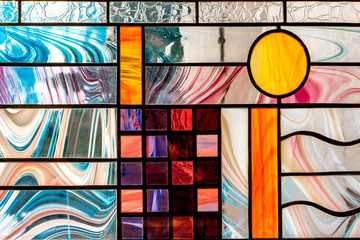 image of a multicolored stained glass window with an irregular block pattern, an abstract pattern...